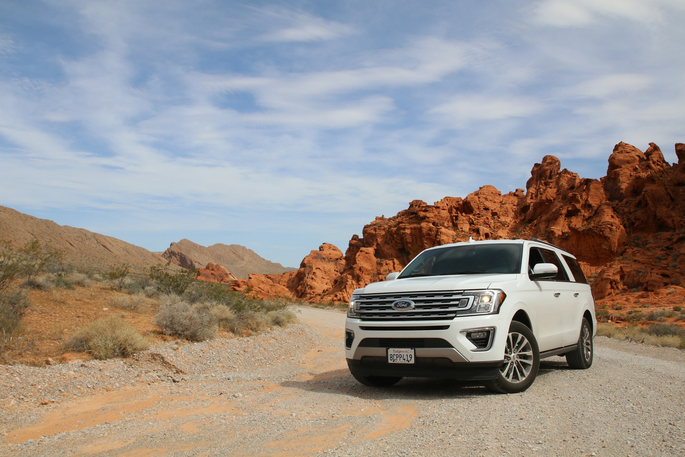 White SUV on a desert canyon road