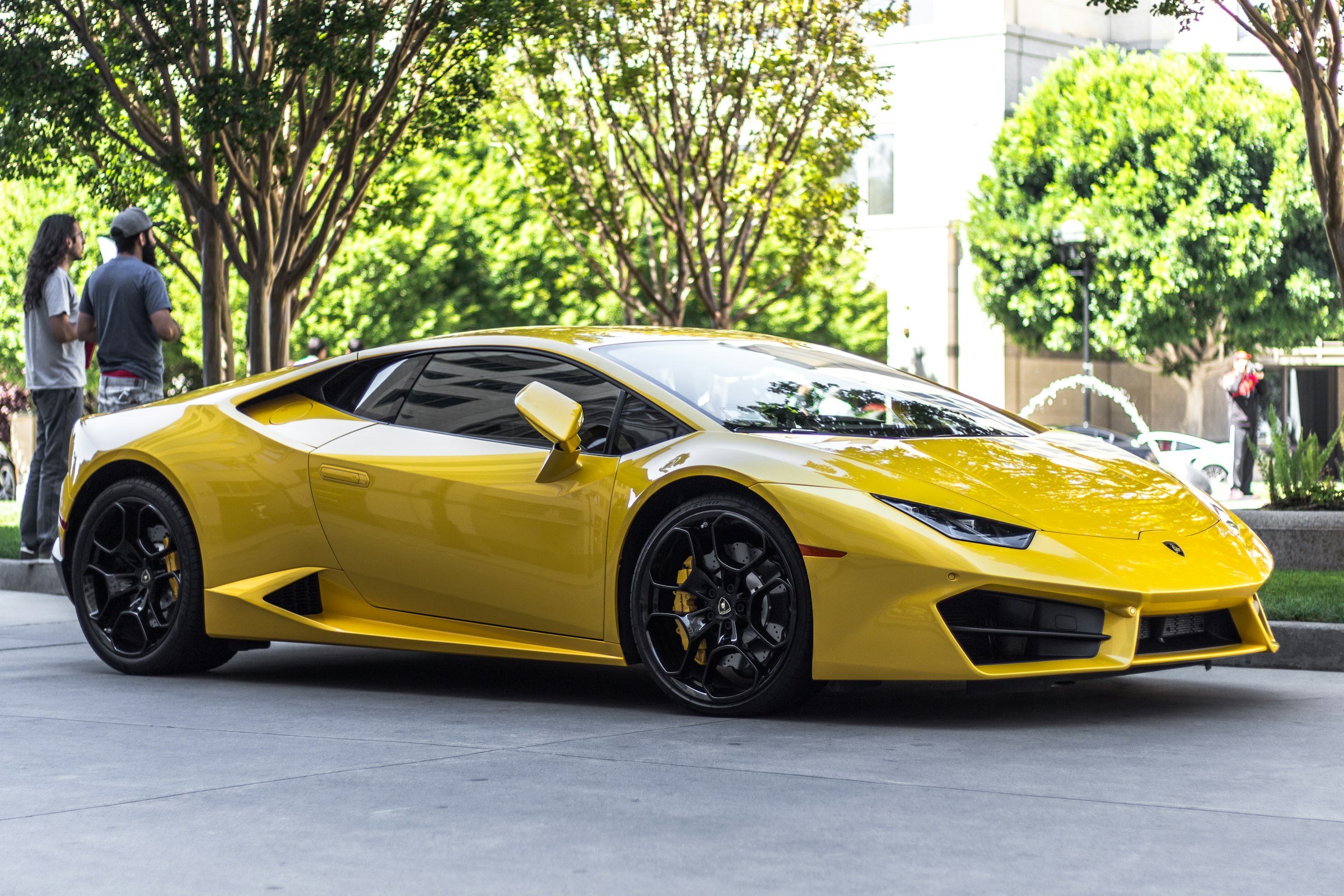 Yellow supercar on a tree-lined city street