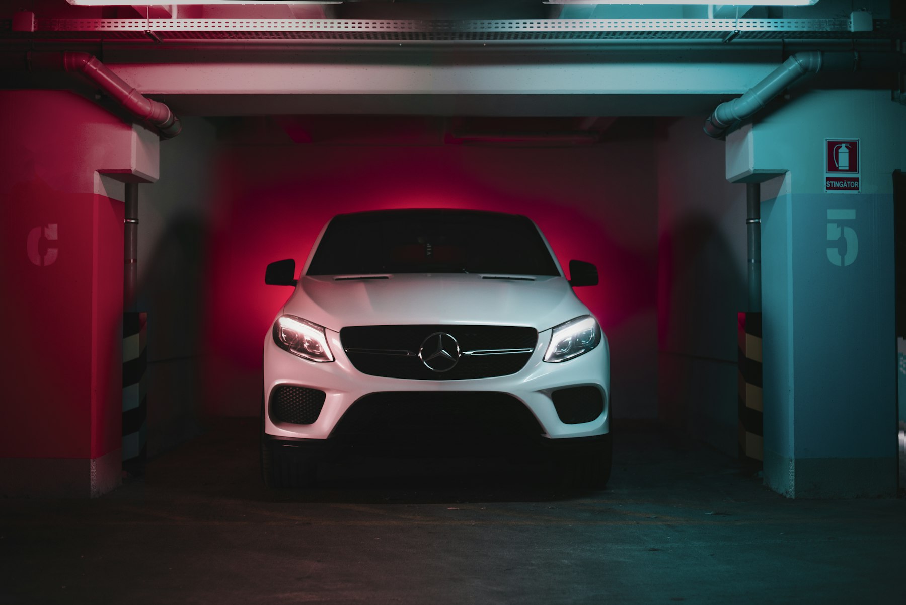 White coupe parked in a moody garage